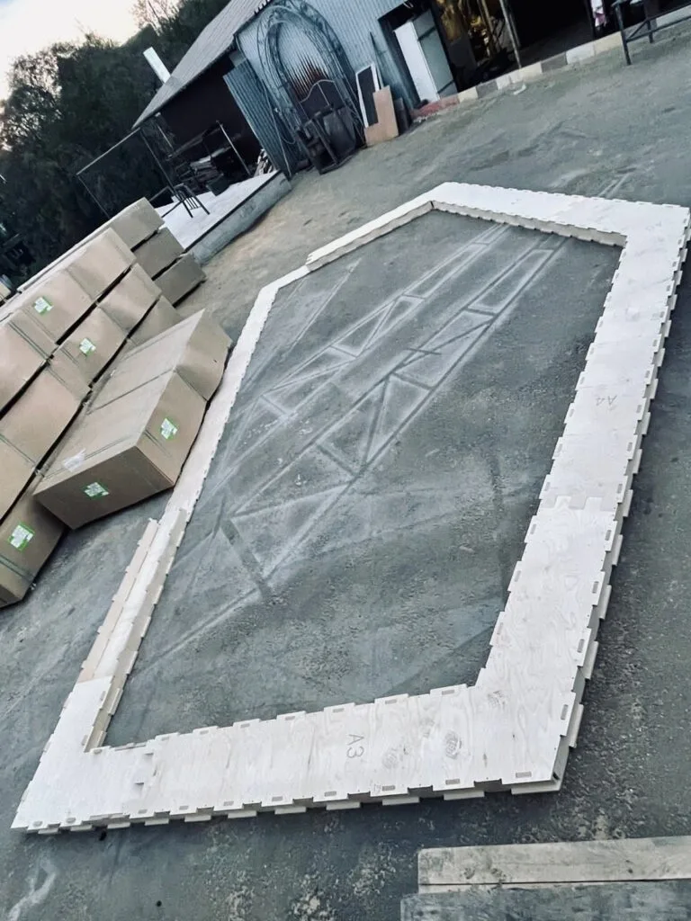 Каркас из деревянных панелей на бетонной площадке для строительства дома на улице
